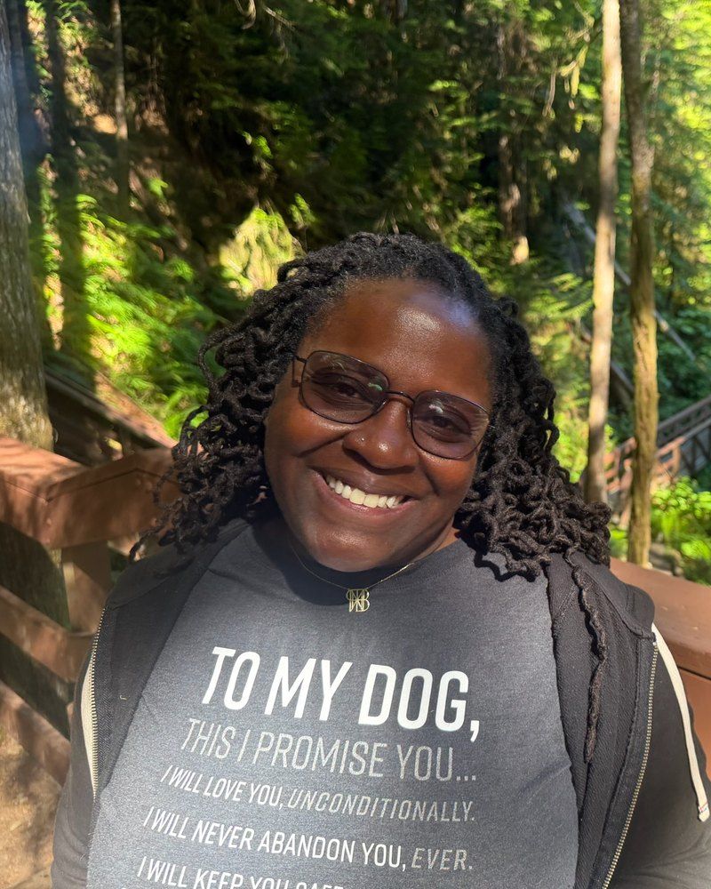 Dr. Kimberly A. Atkinson-Spinks smiling, outdoors on a forest boardwalk